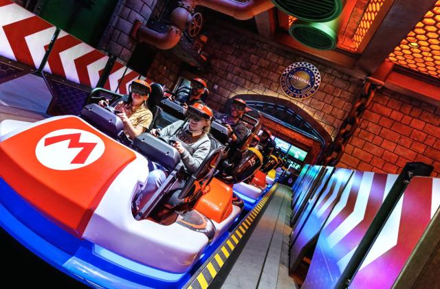 Park patrons wear augmented reality headsets and ride go-karts at Universal Studios Hollywood.