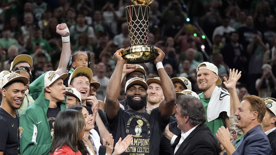 Associated Press - Jaylen Brown, centro, de los Celtics de Boston, alza el trofeo de campeonato Larry O'Brien mientras celebra con su equipo la conquista del título de la NBA con una victoria en el Juego 5 de las Finales de la NBA al superar a los Mavericks de Dallas, el lunes 17 de junio de 2024, en Boston. (AP Foto/Charles Krupa)