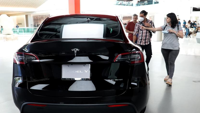 MIAMI, FLORIDA - OCTOBER 21: People look at a Tesla Model Y electric vehicle on a showroom floor at the Miami Design District on October 21, 2021 in Miami, Florida. Tesla reported $1.6 billion in profits for the months of July, August, and September, a record for them.  (Photo by Joe Raedle/Getty Images)