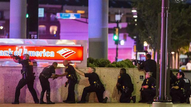 Dallas police officers take cover Thursday night after snipers ambushed cops during a demonstration organized to protest this week’s police-involved shootings in Minnesota and Louisiana. (AP)