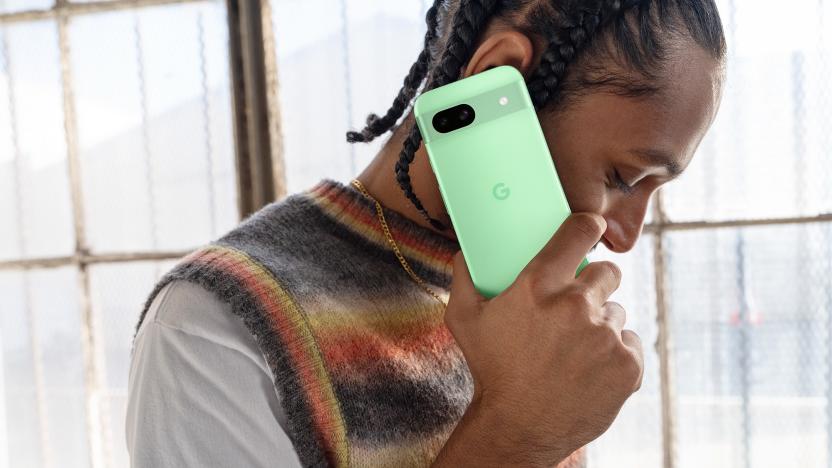 A person holds the new Pixel 8a in the Aloe colorway.
