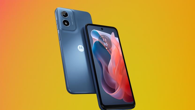 Product marketing image of the Moto G Play (in blue with a blue and red wallpaper). Two phones (one front-facing and one back-facing) sit in front of an orange-yellow gradient background.