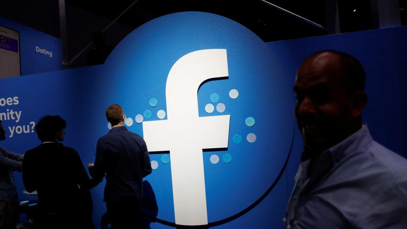 Attendees walk past a Facebook logo during Facebook Inc's F8 developers conference in San Jose, California, U.S., April 30, 2019.  REUTERS/Stephen Lam