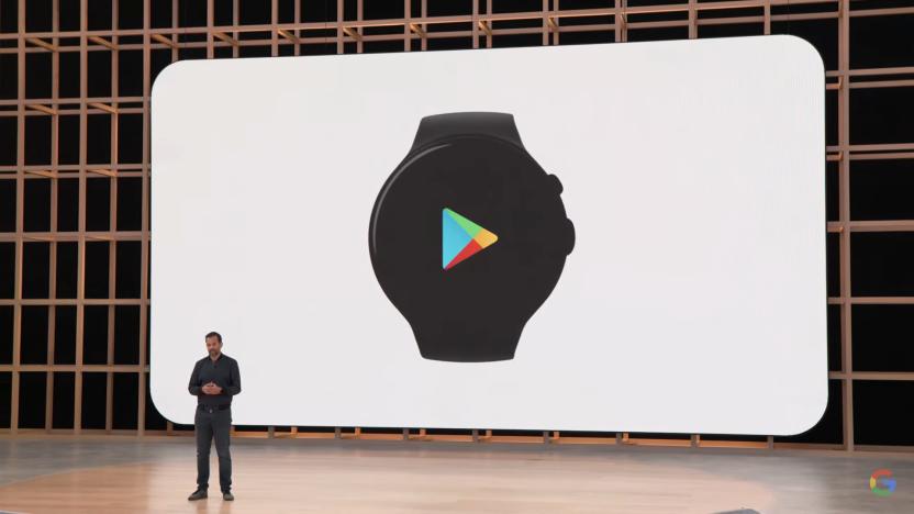 A man standing on stage at Google I/O 2022, in front of a screen showing the Wear OS logo surrounded by eight other third-party logos.