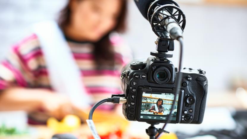 View through digital camcorder display of woman cooking meal, food vlogger making video at home, healthy eating, nutrition