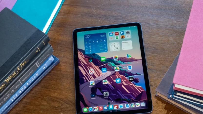 An iPad on a desk surrounded by books. 