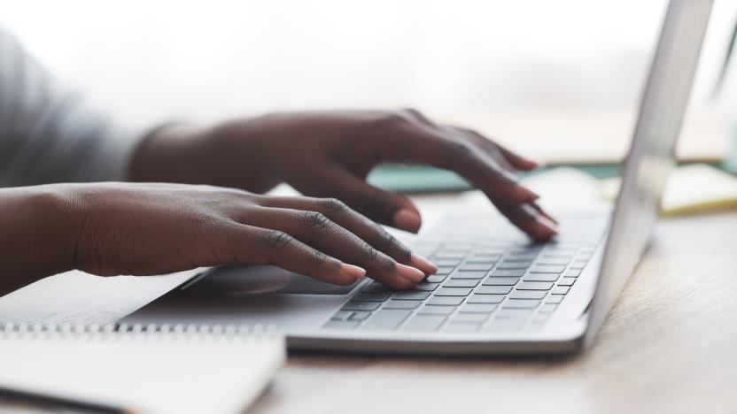 Closeup of unrecognizable afro woman typing on laptop keyboard while working in office, panorama