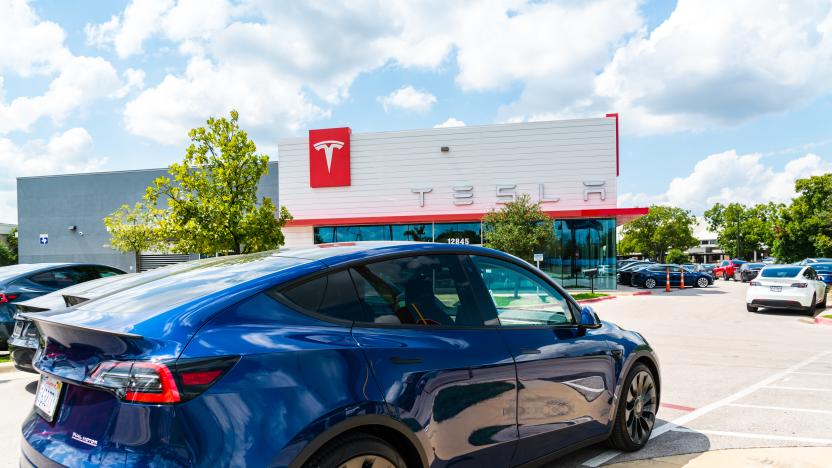 Blue Tesla Model Y in front of Tesla Building in Northwest Austin on a nice sunny afternoon