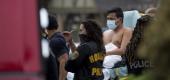 Paramedics transport a man into an ambulance from the scene of a human smuggling case. (AP)