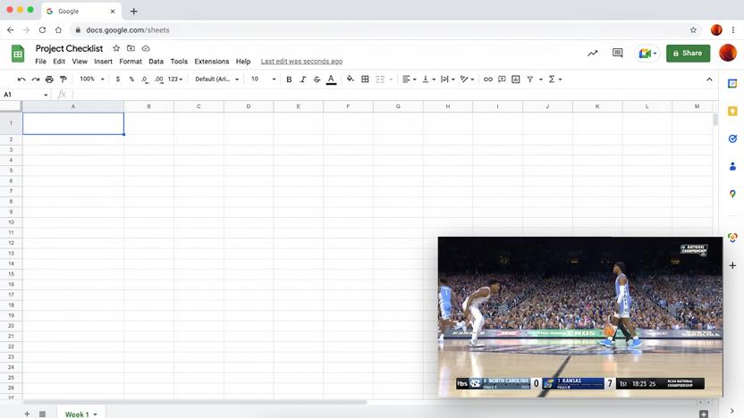 A view of a web browser with a Google Sheets spreadsheet open. A pop-up video player window sits on the lower right, showing live action from an NCAA Tournament game.