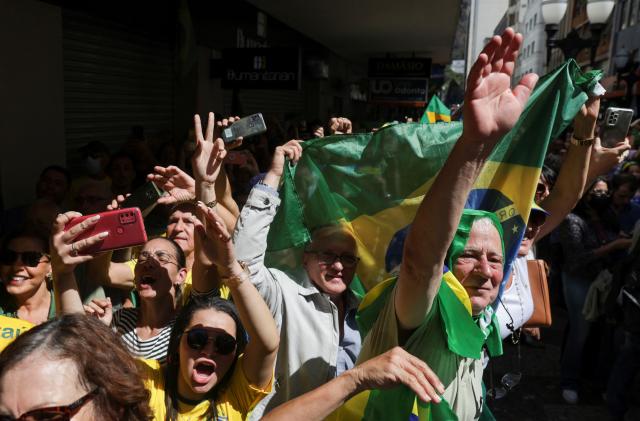 Supporters carry flags as they attend a campaign rally of Brazil's President and candidate for re-election Jair Bolsonaro, in Juiz de Fora, Brazil August 16, 2022. REUTERS/Ricardo Moraes