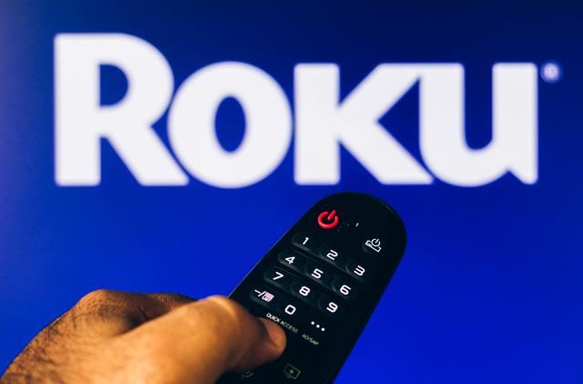 BRAZIL - 2022/02/21: In this photo illustration, a hand holding a TV remote control points to a screen that displays the Roku logo. (Photo Illustration by Rafael Henrique/SOPA Images/LightRocket via Getty Images)
