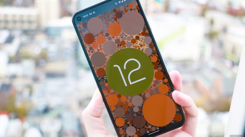 A phone showing the Android 12 easter egg, which is the OS logo on a background of circles themed to the system's color scheme.