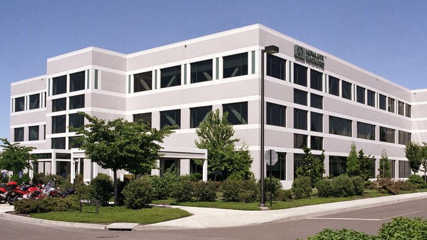 HP office building in Corvallis, Oregon. Gray / off-white building surrounded by trees.