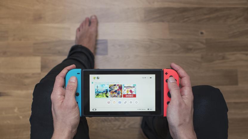 Gothenburg, Sweden - March 10, 2017: A shot from above of a young man's hands holding a neon coloured Nintendo Switch video game system developed and released by Nintendo Co., Ltd. in 2017. The system is turned on and its main menu is showing on the display. Shot on a hardwood floor background in a home environment.