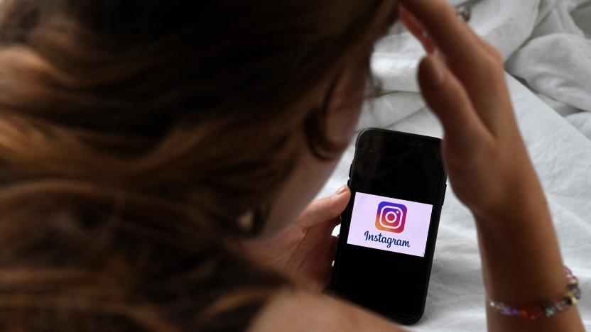 In this photo illustration, a person looks at a smart phone with a Instagram logo displayed on the screen, on August 17, 2021, in Arlington, Virginia. (Photo by OLIVIER DOULIERY / AFP) (Photo by OLIVIER DOULIERY/AFP via Getty Images)