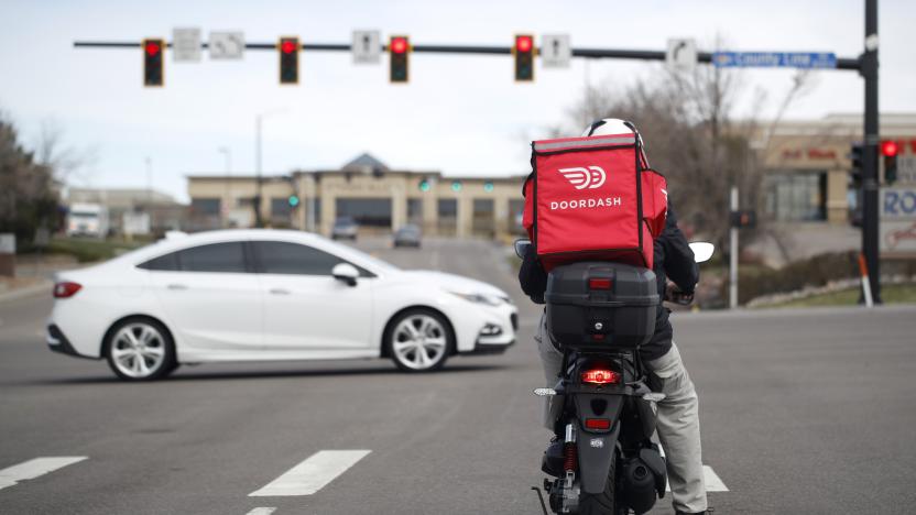 FILE - A food delivery rider waits for the traffic light to change to head northbound on Chester Street at County Line Road as a statewide stay-at-home order remains in effect in an effort to reduce the spread of the new coronavirus Monday, March 30, 2020, in Lone Tree, Colo. State regulators approved permits for DoorDash and Instacart to deliver drinks earlier this week, the Division of Alcoholic Beverage Control confirmed on Friday, Nov. 17, 2023. (AP Photo/David Zalubowski, File)