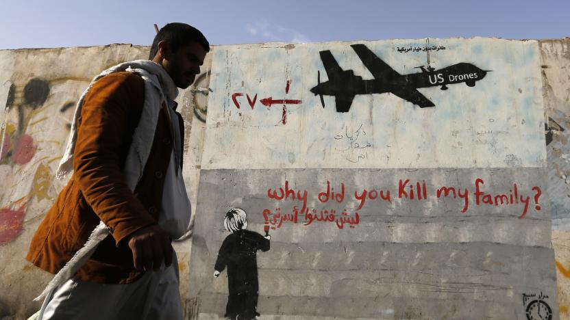 A man walks past a graffiti, denouncing strikes by U.S. drones in Yemen, painted on a wall in Sanaa November 13, 2014. Yemeni authorities have paid out tens of thousands of dollars to victims of drone strikes using U.S.-supplied funds, a source close to Yemen's presidency said, echoing accounts by legal sources and a family that lost two members in a 2012 raid. REUTERS/Khaled Abdullah (YEMEN - Tags: CIVIL UNREST MILITARY POLITICS SOCIETY TPX IMAGES OF THE DAY)