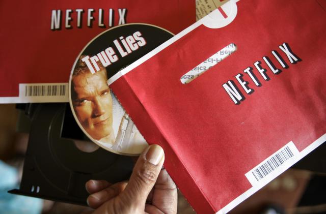 File - Mei Michelson prepares to watch a Netflix DVD at her home in Palo Alto, Calif., on Oct. 22, 2007. The Netflix DVD-by-service will mail out its final discs Friday from its five remaining distribution centers, ending its 25-year history. (AP Photo/Paul Sakuma, File)