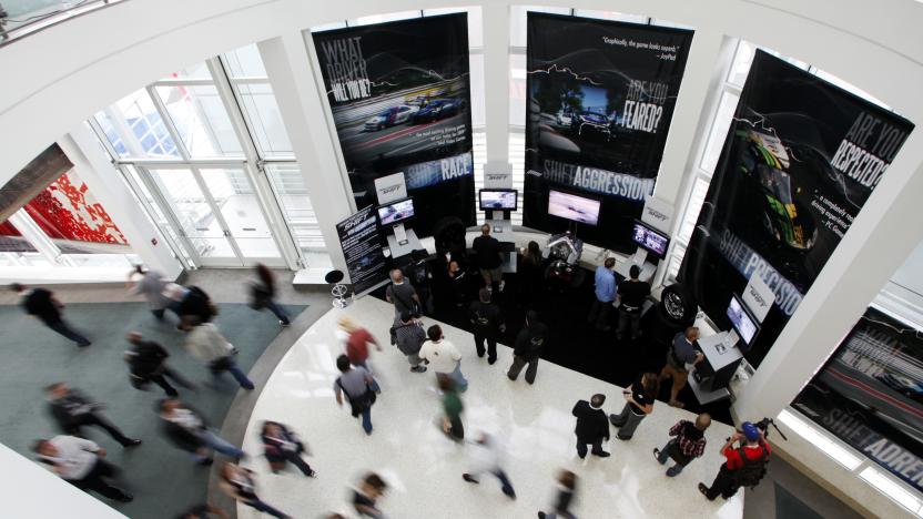 Visitors play the Electronic Arts' video game "Need for Speed Shift" as others make their way through the hallway during the Electronic Entertainment Expo or E3 in Los Angeles, June 3, 2009. The convention runs June 2-4. REUTERS/Danny Moloshok (UNITED STATES BUSINESS)