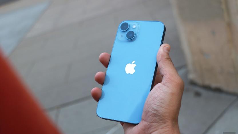 The iPhone 14 held in a hand with its rear cameras facing out.