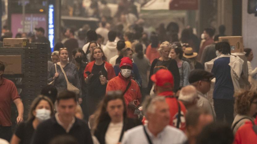 FILE - People wear face masks as they walk outside in the smoke-filled air in Herald Square, June. 7, 2023, in New York. More Americans believe they've personally felt the impact of climate change because of recent extreme weather according to new polling from The Associated Press-NORC Center for Public Affairs Research. (AP Photo/Yuki Iwamura, File)