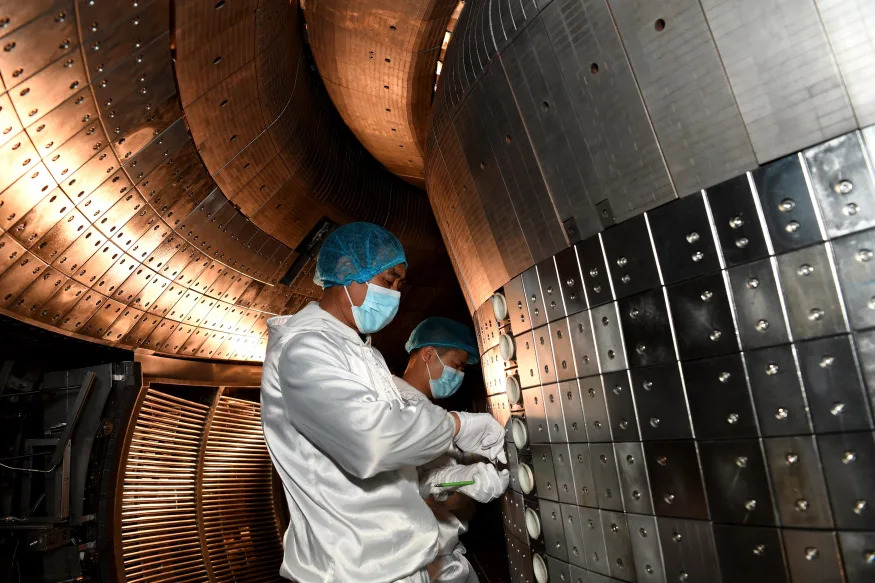 Staff members perform an upgrade to the experimental advanced superconducting tokamak EAST at the Hefei Institutes of Physical Science under the Chinese Academy of Sciences CAS on April 28, 2021. Chinese scientists have set a new world record of achieving a plasma temperature of 120 million degrees Celsius for a period of 101 seconds in the latest experiment on Friday, a key step toward the test running of a fusion reactor. The experiment at the experimental advanced superconducting tokamak EAST, or the 