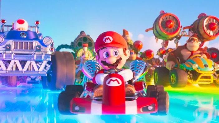 Mario races down a track with Toad and Donkey Kong behind him. 