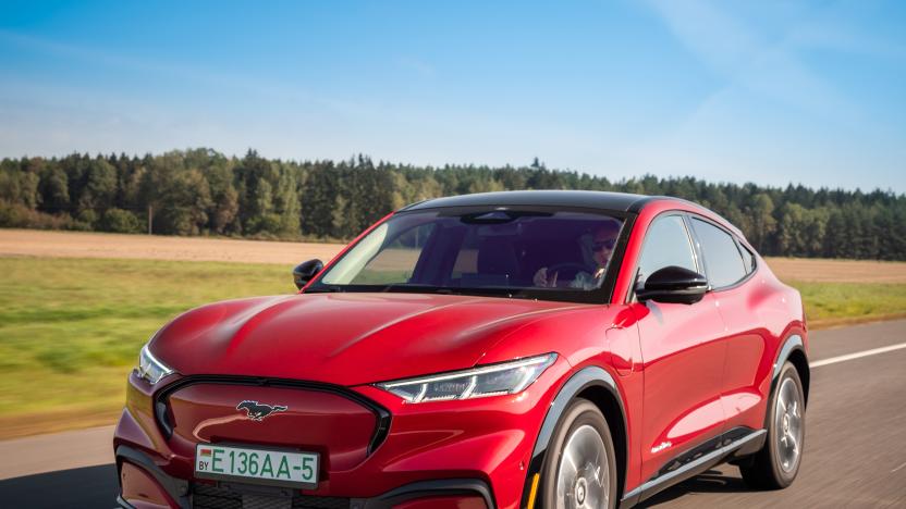 Minsk, Belarus - September 10, 2021: All-electric bright red Ford Mustang Mach-E drives on a highway during a sunny day.