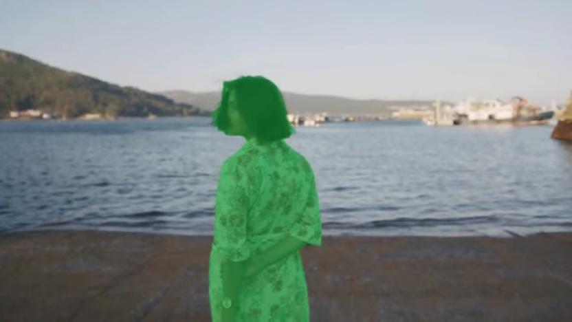 A green screen mask over a person in Runway's AI-powered content creation suite. A seaside scene is in the background.