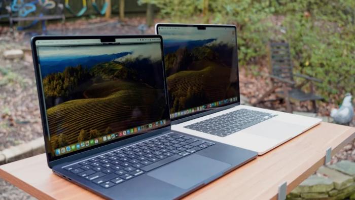 Two laptops on a table outside. 