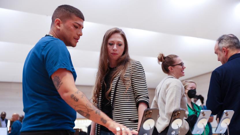 Chelsea Clinton is shown the Apple iPhone 14 range by a worker at the Apple Fifth Avenue store in Manhattan, New York City, U.S., September 16, 2022.  REUTERS/Andrew Kelly