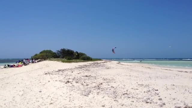 Kite surfer jumps over island, lands back on water!