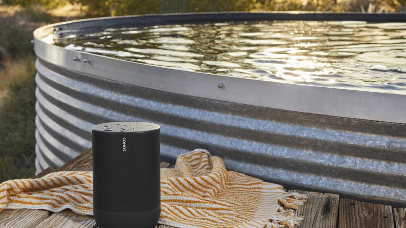 The Sonos Move speaker sits on a wooden bench near a corrugated tin swimming pool with a orange and white towel nearby. The speaker has water drops on it to demonstrate its water resistance. 