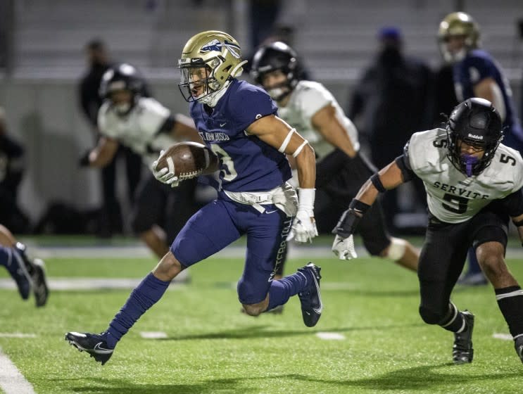 BELLFLOWER, CA - March 26: St. John Bosco wide receiver Jode McDuffie, center, outruns Servite linebacker Aden &quot;Ace&quot; Eckenwiler, right, in the second half at St. John Bosco High School on Friday, March 26, 2021 in Bellflower, CA. (Allen J. Schaben / Los Angeles Times)