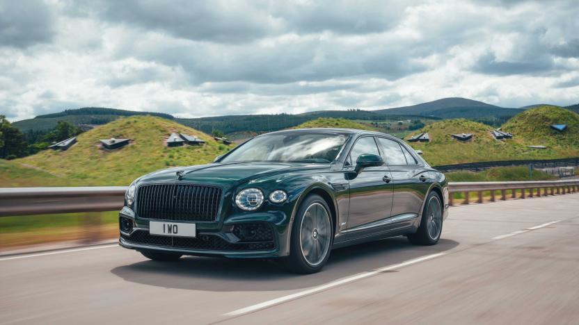 The Bentley Flying Spur plug-in hybrid drives down a highway with hills in the background.