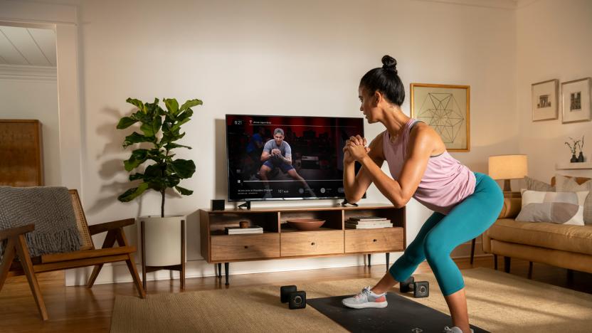 A person works out at home using the Peloton app.