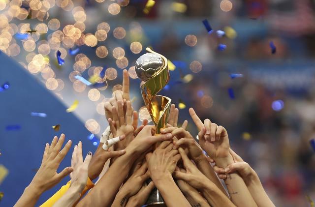 FILE - In this July 7, 2019, file photo, the United States players hold the trophy as they celebrate winning the Women's World Cup final soccer match against The Netherlands at the Stade de Lyon in Decines, outside Lyon, France. The 2023 Women's World Cup will be spread across nine cities in Australia and New Zealand. (AP Photo/Francisco Seco, File)