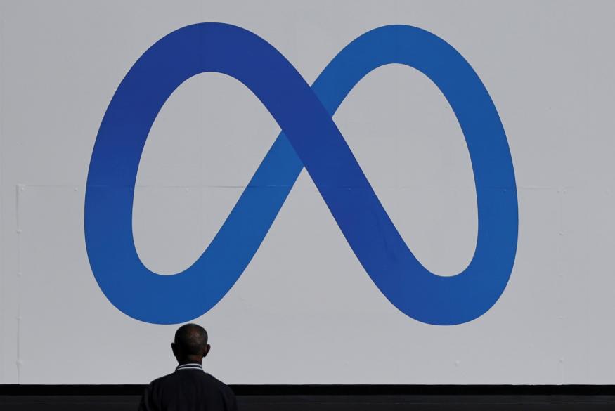 A man stands in front of a sign of Meta, the new name for the company formerly known as Facebook, at its headquarters in Menlo Park, California, U.S. October 28, 2021. REUTERS/Carlos Barria     TPX IMAGES OF THE DAY