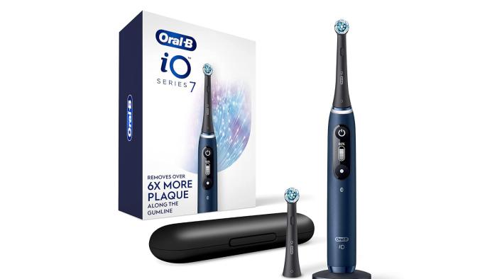 A smart toothbrush with an extra brush head and its box in the background.
