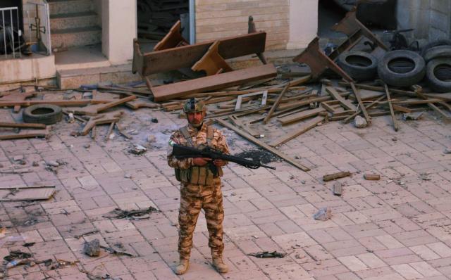 A Christian Peshmerga fighter stands in the desecrated church of Batnay in Northern Iraq. (Photo: Ash Gallagher for Yahoo News) 