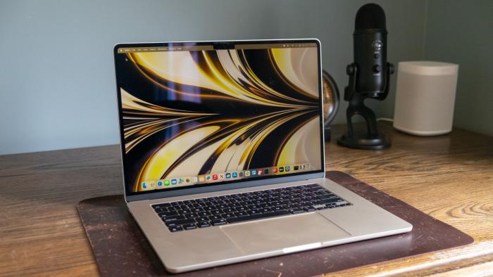 A laptop on top of a wooden desk.