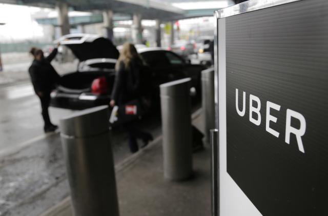 FILE - In this March 15, 2017, file photo, a sign marks a pick up point for the Uber car service at LaGuardia Airport in New York. Uber will resume testing autonomous vehicles in an area near Downtown Pittsburgh starting Thursday, Dec. 20, 2018. (AP Photo/Seth Wenig, File)