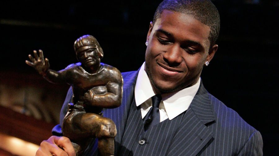 Reuters - Winner of the 2005 Heisman Trophy, Reggie Bush of the University of Southern California, lifts the award in New York December 10, 2005. REUTERS/Julie Jacobson/Pool