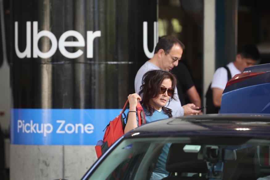 CHICAGO, ILLINOIS - MAY 09: Travelers wait for an Uber ride at Midway International Airport on May 09, 2022 in Chicago, Illinois. Uber plans to cut spending and hiring in an attempt slow the company's plummeting stock price, which is down nearly 50 percent for the year.   (Photo by Scott Olson/Getty Images)