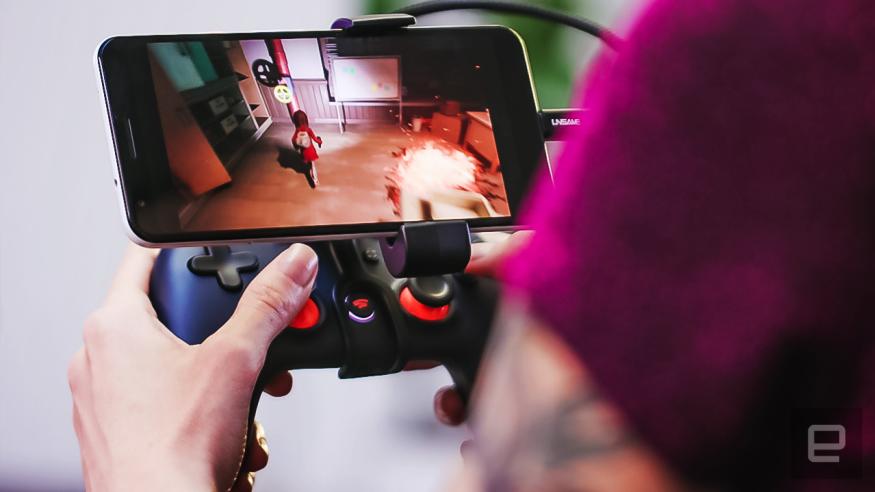 An over-the-shoulder view of someone playing a Google Stadia game on a mobile device with a controller.