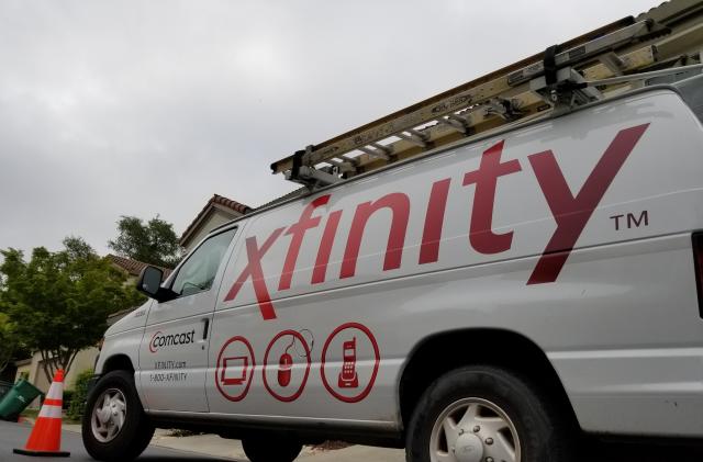 San Ramon, California, United States - May 17, 2018:  Low angle view of Comcast Xfinity cable television installation truck parked on a street in front of a suburban home, San Ramon, California, May 17, 2018