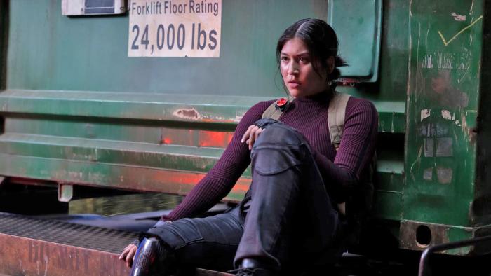 A young woman sits with one foot resting on a ledge in new Marvel series Echo.  