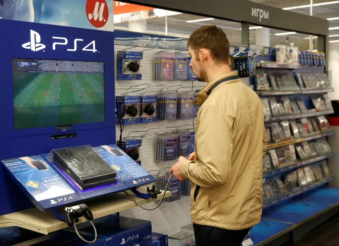 A customer plays a game on PlayStation 4 (PS4) in a store of Russia's biggest electrical and white goods retailer M.video in Moscow, Russia, April 15, 2016. REUTERS/Maxim Zmeyev