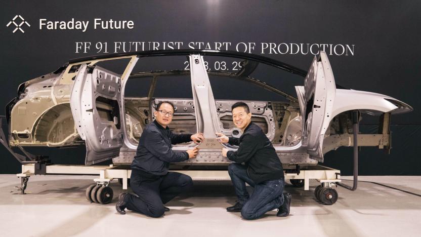 A photo of the Faraday Future FF91 Futurist electric vehicle frame with two of the FF team kneeling in front of it.